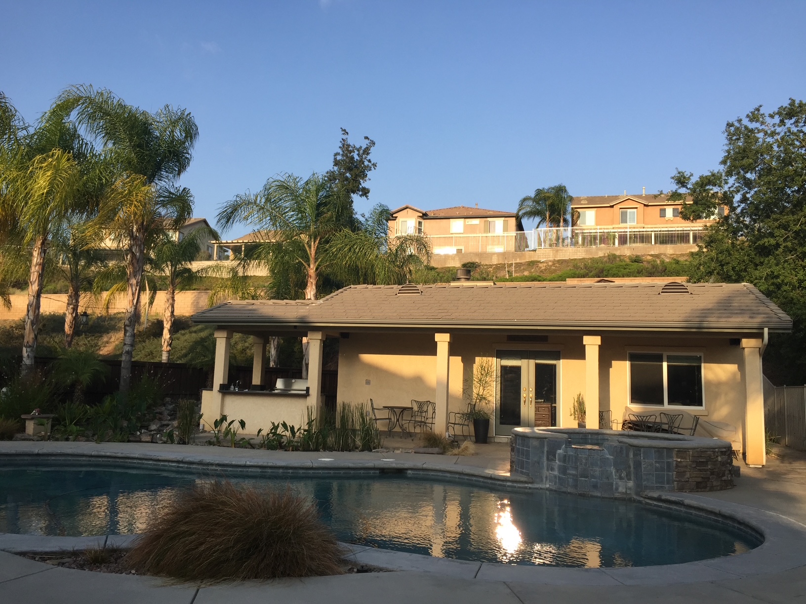 Pool house with covered patio and outdoor kitchen
